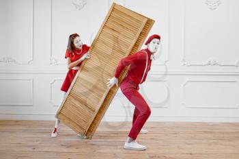 Two mime artists, clowns with wooden partition. Pantomime theater, parody comedian, positive emotion, humour performance, funny face mimic and grimace