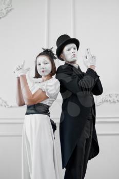 Two mime artists with guns, gangsters parody. Pantomime theater, comedian, positive emotion, humour performance, funny face mimic and grimace