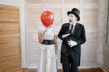 Two mime artists with air balloon, comedy parody. Pantomime theater, comedian, positive emotion, humour performance, funny face mimic and grimace