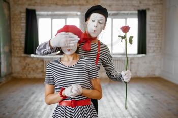 Two mime artists, surprise with rose scene, parody comedy. Pantomime theater, comedian, positive emotion, humour performance, funny face mimic and grimace