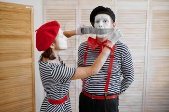 Two mime artists with duct tape, parody comedy. Pantomime theater, comedian, positive emotion, humour performance, funny face mimic and grimace