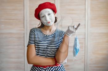 Female mime artist with medical mask. Pantomime theater, comedian parody, positive emotion, humour performance, funny face mimic and grimace