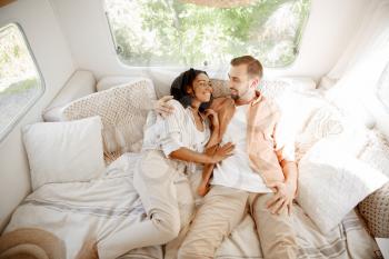 Love couple embraces in rv bed, camping in a trailer. Man and woman travels on van, romantic vacations on motorhome, campers leisures in camping car