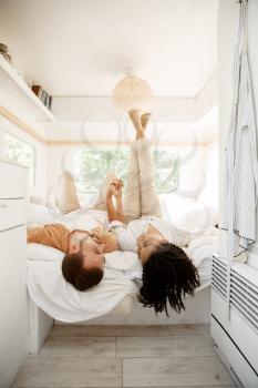 Love couple fooling around in rv bed, camping in a trailer. Man and woman travels on van, romantic vacations on motorhome, campers leisures in camping-car
