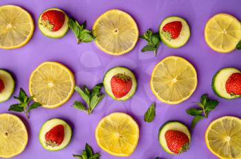 Fresh lemon slices and strawberries isolated on purple background. Organic vegetarian food, grocery assortment, natural eco products, healthy lifestyle concept