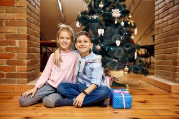 Children bloggers poses at christmas tree, little vloggers. Kids blogging in home studio, social media for young audience, online internet broadcast