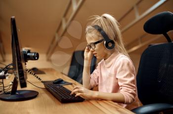Girl in headphones works on PC, little blogger. Kid blogging in home studio, social media for young audience, online internet broadcast, creative hobby