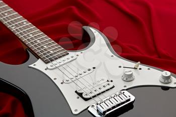 Modern electric guitar, red background, nobody. String musical instrument, electro sound, electronic music, equipment for stage concert