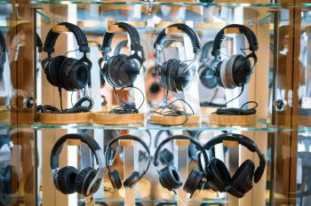 Headphones on the showcase in audio store, nobody. Speaker system choice, stand with earphones, multimedia salon assortment, music devices shop