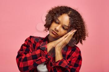 Young tired woman portrait, pink background, emotion. Face expression, female person looking on camera in studio, emotional concept, feelings
