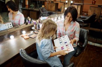 Mother and daughter having fun in make-up salon. Mom and little girl play stylists together, happy childhood, glamour family