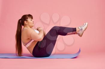Overweight woman doing abs exercise, body positive, pink background. Obesity fighting, striving for a healthy lifestyle