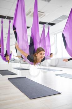 Fly antigravity yoga, group training with hammocks. Fitness, pilates and dance exercises mix. Women on yogi workout in sports studio