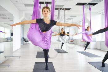 Fly anti-gravity yoga, female group training with hammocks. Fitness, pilates and dance exercises mix. Women on yoga workout