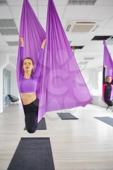 Fly yoga, female group training, hanging on hammocks. Fitness, pilates and dance exercises mix. Women on yoga workout