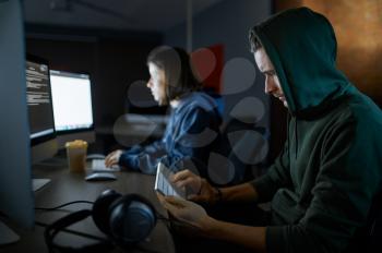 Male and female hackers works on computers in darknet, dangerous teamwork. Illegal web programmer at workplace, criminal occupation. Data hacking.