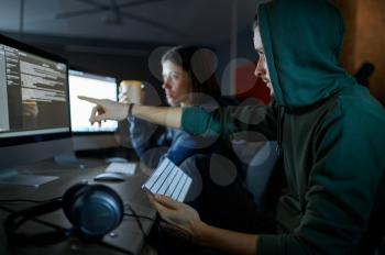 Male and female hackers works on computers in darknet, dangerous teamwork. Illegal web programmer at workplace, criminal occupation. Data hacking, cyber security