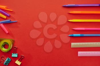 Pens, rulers and paper clips, red background. Office stationery supplies, school or education accessories, writing and drawing tools
