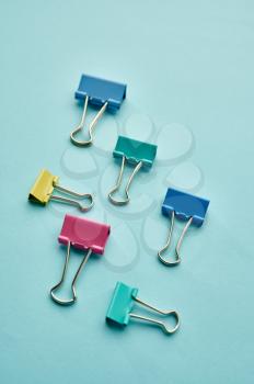 Set of colorful clips on blue background. Office stationery supplies, school or education accessories, writing and drawing tools
