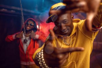Two smiling rappers, breakdancing in studio with cool underground decoration. Hip-hop performers, trendy rap singers, break-dancers
