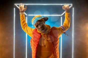 Young stylish rapper poses in illuminated cube. Hip-hop performer, rap singer, break-dance performing, entertainment lifestyle