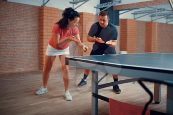 Man and woman on table tennis training, ping pong players. Couple playing table-tennis indoors, sport game with racket and ball, active healthy lifestyle