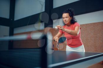 Woman hits ball at the wall, table tennis training, ping pong player. Sportive girl playing table-tennis indoors, sport game with racket, active healthy lifestyle