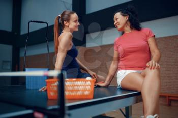 Women relaxing after table tennis match, female ping pong players. Friends playing table-tennis indoors, sport game with racket and ball, active healthy lifestyle
