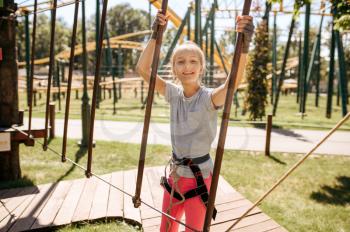 Brave kids in equipment climbs in rope park, playground. Children climbing on suspension bridge, extreme sport adventure on vacations, entertainment outdoors