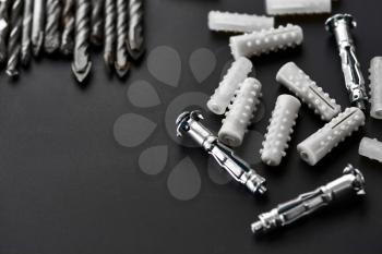 Set of borers, anchor bolts and dowels, grey background, nobody. Professional instrument, builder equipment, drilling tools, ceramic and concrete drills