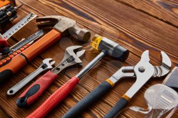 Different workshop tools, macro view, wooden background, nobody. Professional instrument, carpenter or builder equipment, screwdriver and wrench, piles and metal scissors