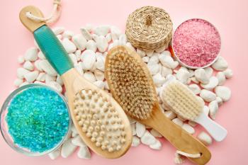 Skin care products on pebbles, macro view, pink background, nobody. Healthcare procedures concept, hygiene tools