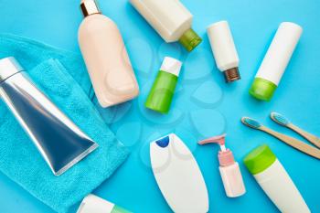 Oral and skin care products, blue background, nobody. Morning healthcare procedures concept, toothcare, toothbrush and toothpaste, brush and cream in bottle