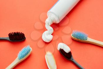 Oral care products, red background, nobody. Morning healthcare procedures concept, toothcare, toothbrush and toothpaste tube