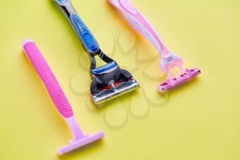 Skin care products, razors on yellow background, nobody. Healthcare procedures concept, shaving tools, blades or shavers