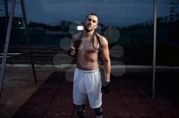 Athletic man after exercises, street workout, crossfit. Fitness training on sports ground outdoor, male person pumps muscles, active urban lifestyle