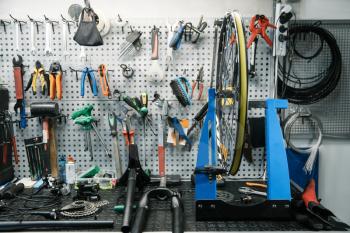 Bicycle workshop interior, tools on the wall. Professional cycle repairing service, hardware and equipment for bike assembly