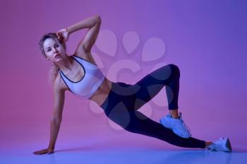 Sexy female athlete, training in studio, neon background. Fitness woman at the photo shoot, sport concept, active lifestyle motivation
