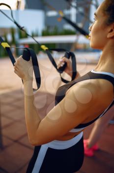 Woman doing exercise with ropes on sports ground outdoors, top view. Slim female person in sportswear, outside fitness training, fit workout