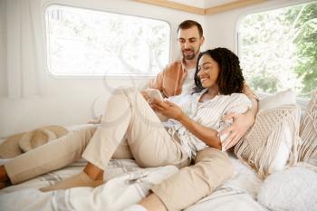 Love couple embraces in rv bed, camping in a trailer. Man and woman travels on van, romantic vacations on motorhome, campers leisures in camping-car