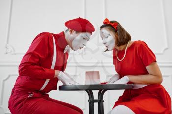Male and female mime artists are looking on gift. Pantomime theater, parody comedian, positive emotion, humour performance, funny face mimic and grimace