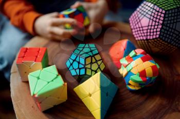 Young boy holds colorful puzzle cube in his hand. Toy for brain and logical mind training, creative game, solving of complex problems
