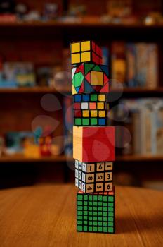 Tower of colorful puzzle cubes on the table, closeup view, nobody. Toy for brain and logical mind training, creative game, solving of complex problems
