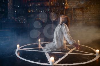 Scary demonic woman sitting in the magic circle, demons casting out. Exorcism, mystery paranormal ritual, dark religion, night horror