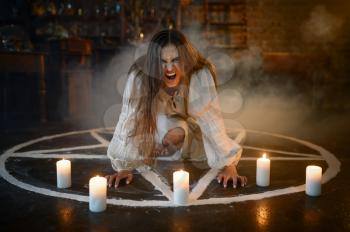 Crazy demonic woman sitting in magic circle with candles, demons casting out. Exorcism, mystery paranormal ritual, dark religion, night horror, potions on shelf on background