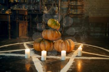 Magic circle with pumpkins and burning candles, nobody, demons casting out. Exorcism concept, mystery paranormal ritual, dark religion, night horror
