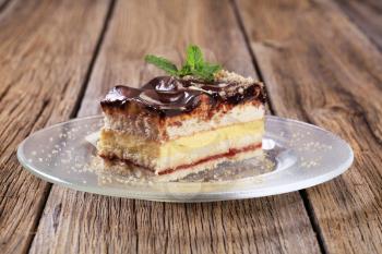 Slice of vanilla cream cake with chocolate icing