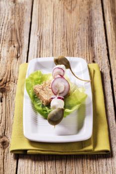 Mozzarella cheese, capers and onion on a wooden skewer