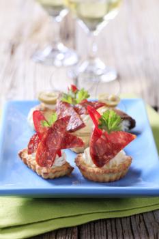 Tartlet based canapes with pieces of spicy salami