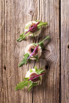 Anchovy canapes with arugula garnished with onion